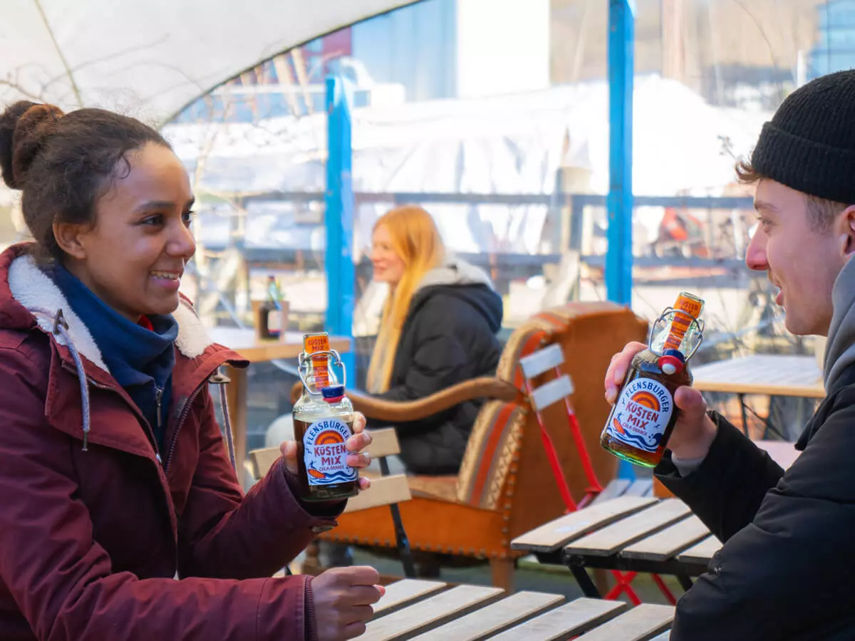 2 Menschen haben einen guten Schnack, während sie Küstenmix trinken.