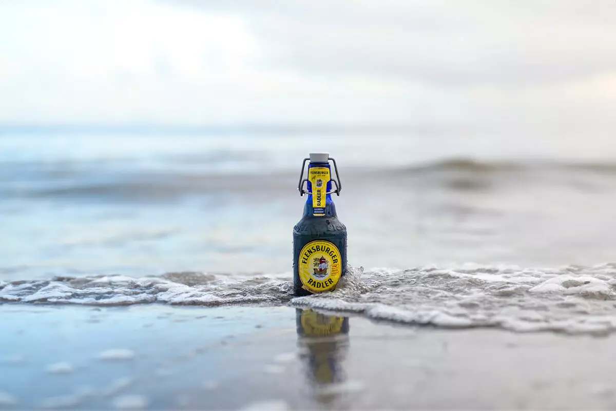 Blaue Flasche Flensburger Radler in der Brandung