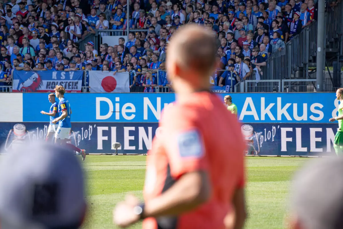 Bandenwerbung von FLENS bei Holstein Kiel.