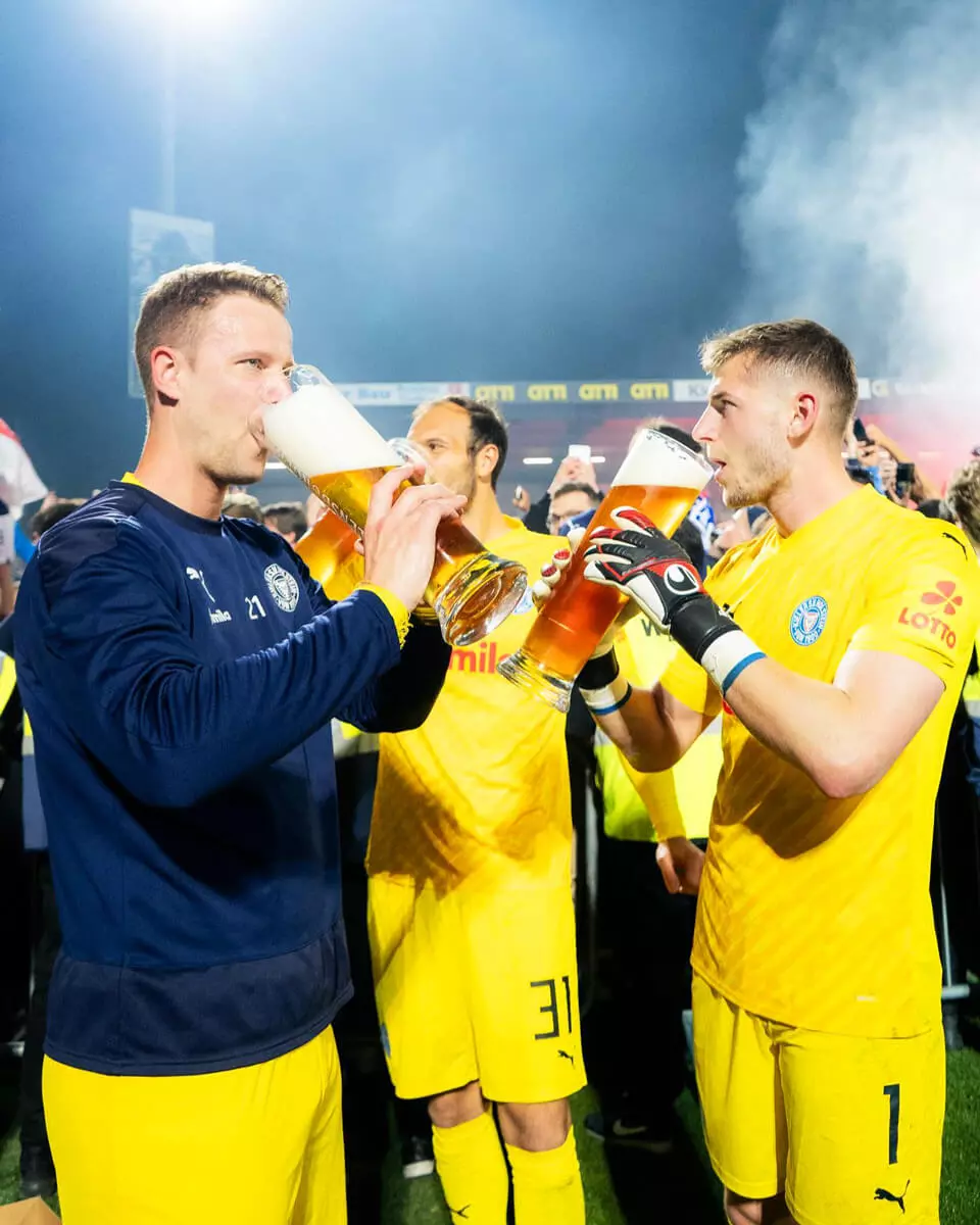 Spieler von Holstein Kiel trinken FLENS aus 2-Liter-Gläsern.