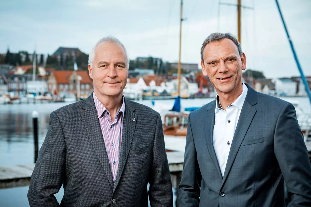 Die Geschäftsführer von FLENS im Anzug am Hafen.