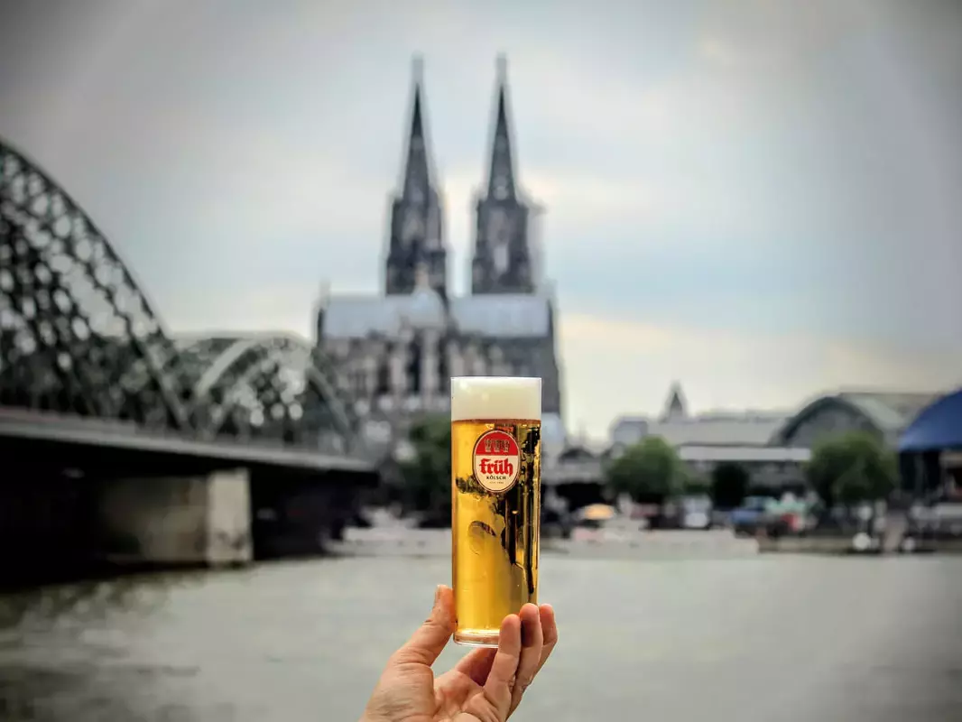 Gefülltes Kölsch-Glas vor Köln-Panorama.